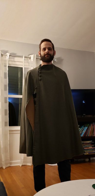 a man wearing a cape standing in a living room