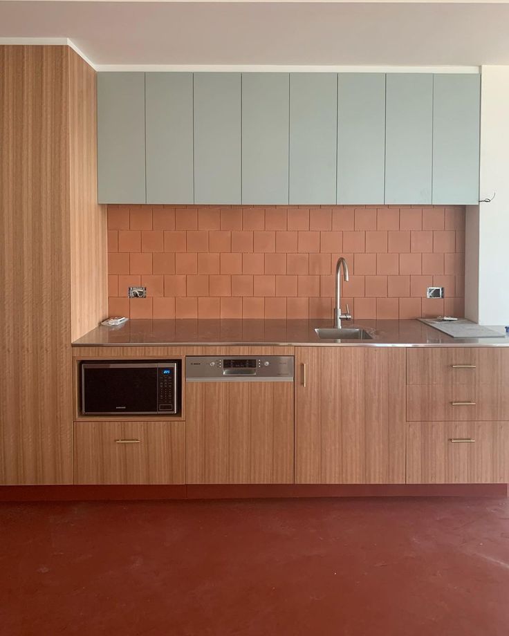 an empty kitchen with wooden cabinets and stainless steel appliances