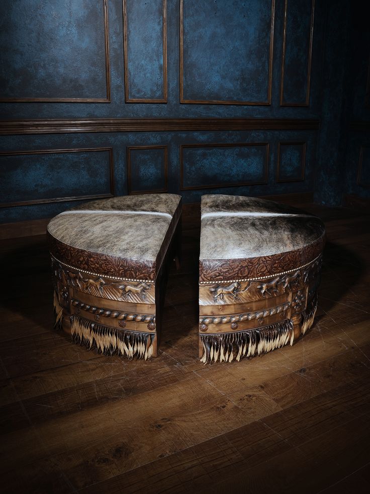 two round ottomans sitting on top of a wooden floor in front of a blue wall