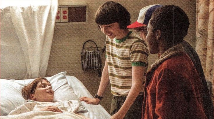 two boys and a girl in a hospital bed talking to one boy who is on the other side of the bed