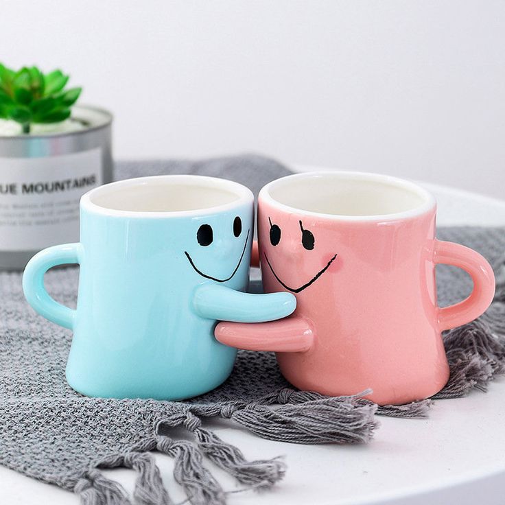 two coffee mugs sitting next to each other on a table