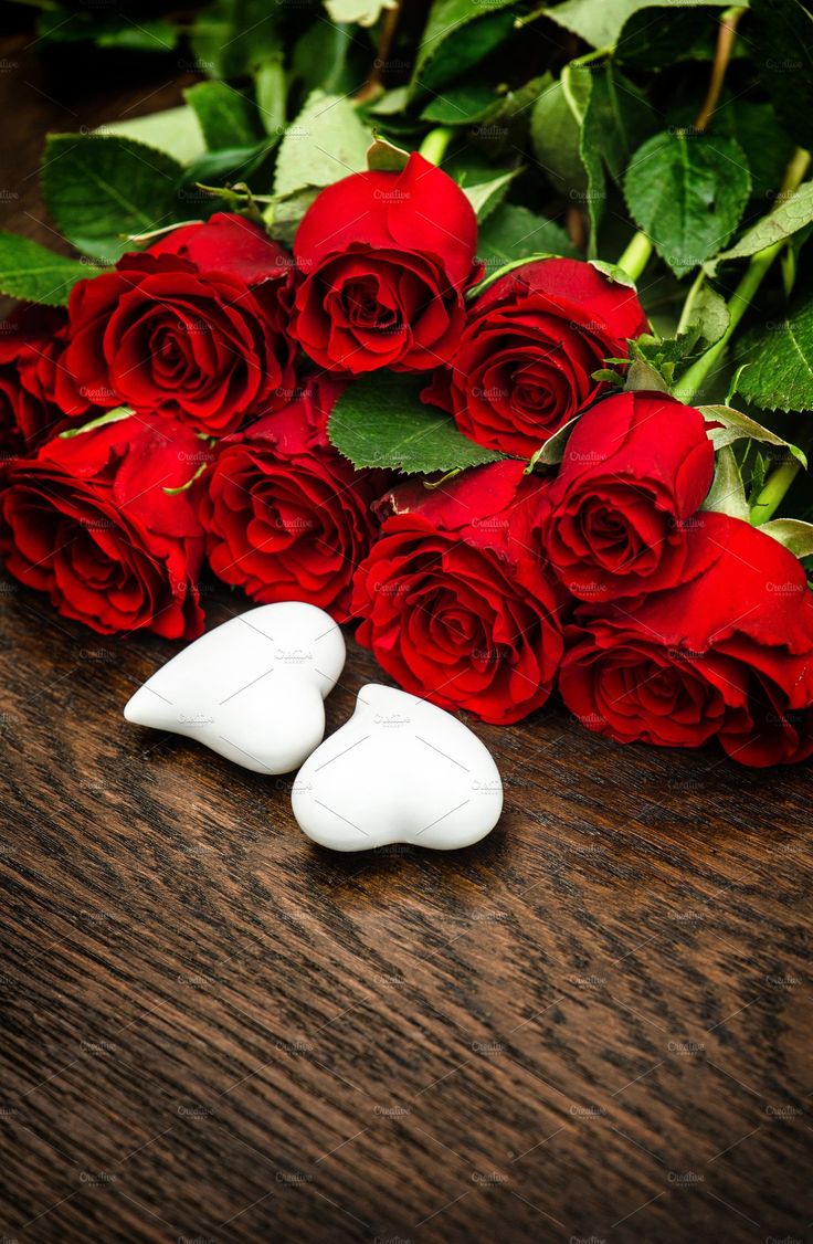 roses and two white hearts on a wooden table with the words rosy morning have a blessed day