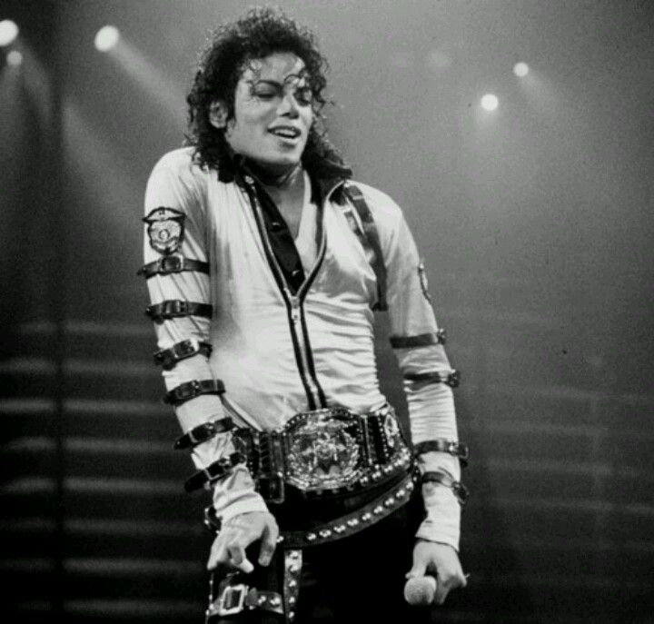 michael jackson performing on stage with his hands in his pockets and belt around his waist