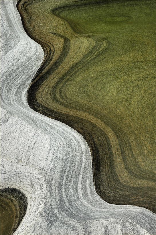 an aerial view of green and white grass with swirly lines in the foreground