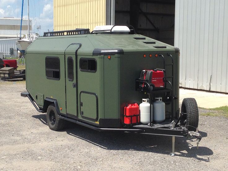 an off - road vehicle parked in front of a building with tanks attached to the back