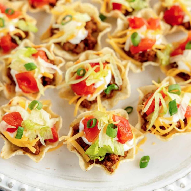 small appetizers are arranged on a white platter, ready to be eaten