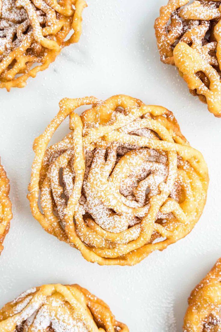 several pastries covered in powdered sugar on a white surface