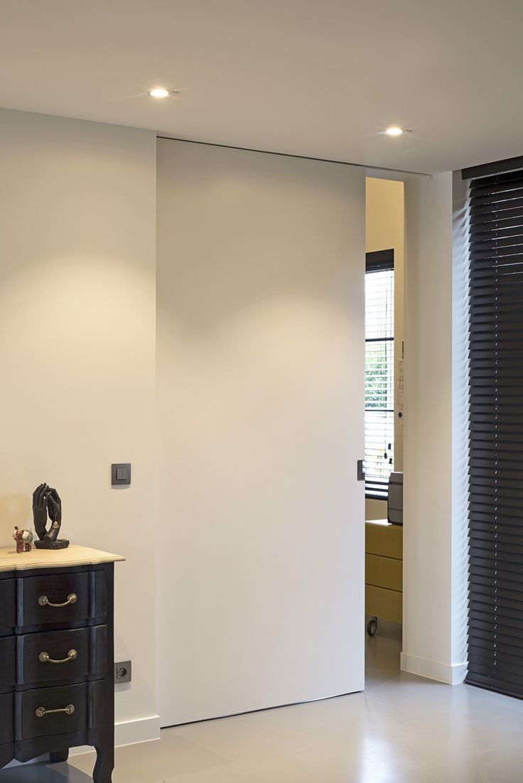 an empty room with white walls and black furniture