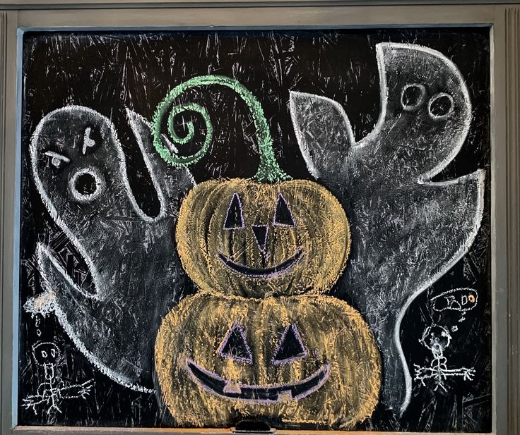 a chalk drawing of two pumpkins with ghost faces