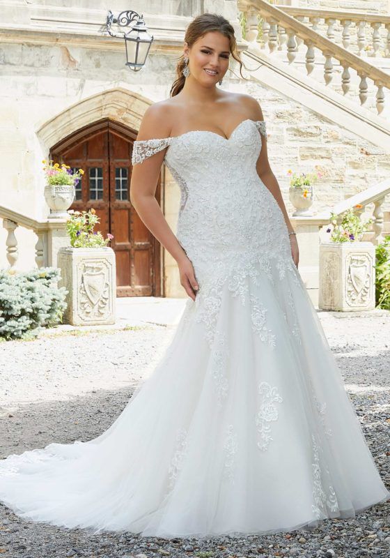 a woman in a wedding dress posing for the camera