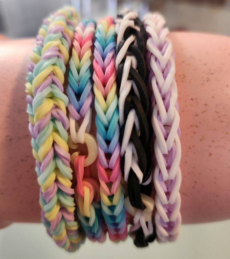 several different colored bracelets are on someone's arm and it looks like they have been made out of rubber bands