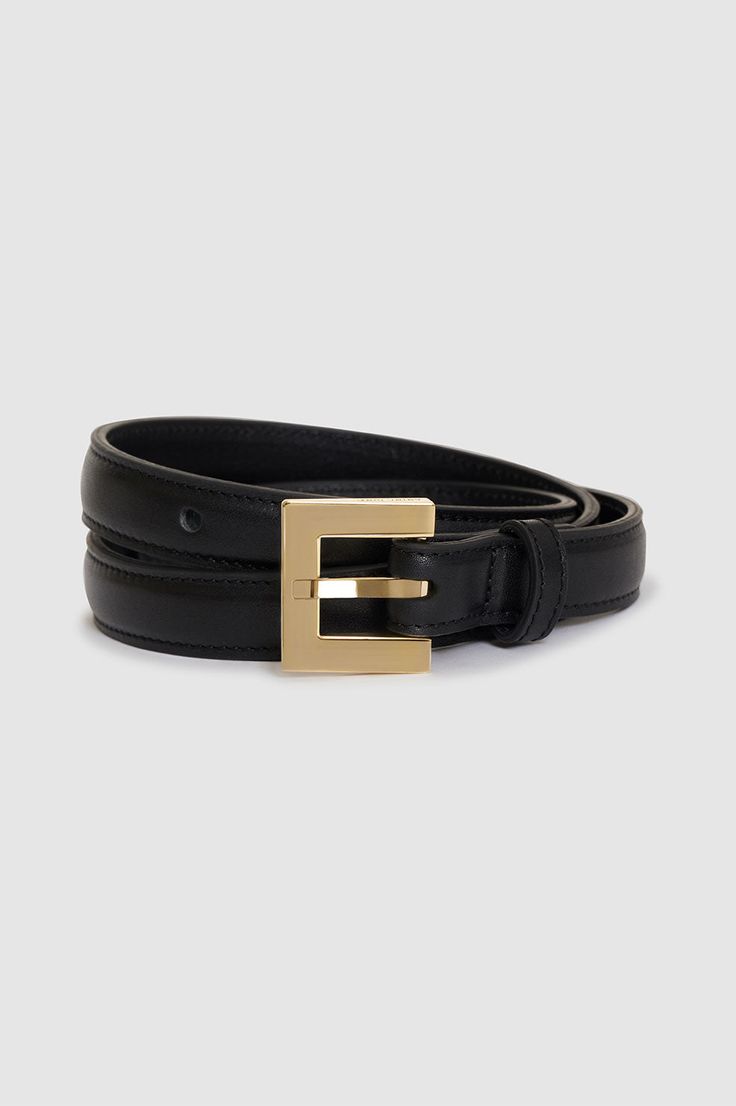 The Nicola Belt is crafted from black 100% cow leather with a slight sheen. This everyday style is slightly padded and features a custom square-shaped buckle in 14k gold-plated zinc engraved with subtle ANINE BING branding. Product Measurements: XS/S: Length: 30", Width: 0.8" M/L: Length: 34", Width: 0.8" 100% Cow Leather Spot clean Made in Turkey Gold Belt With Rectangular Buckle For Business, Classic Belts With Gold Buckle, Classic Belts With Gold Rectangular Buckle, Black Timeless Formal Belt Buckles, Timeless Black Formal Belt Buckles, Elegant Black Rectangular Belt Buckle, Timeless Black Belt Buckles For Formal Wear, Timeless Black Belt, Formal Belts With Gold Rectangular Buckle