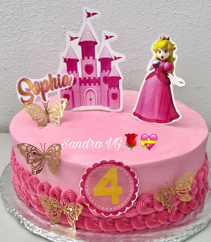 a pink birthday cake with a princess figure on top