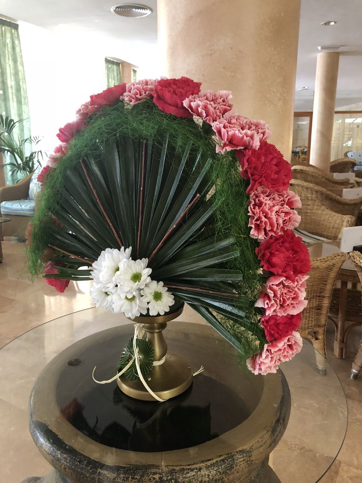 a vase filled with flowers sitting on top of a table next to a glass table