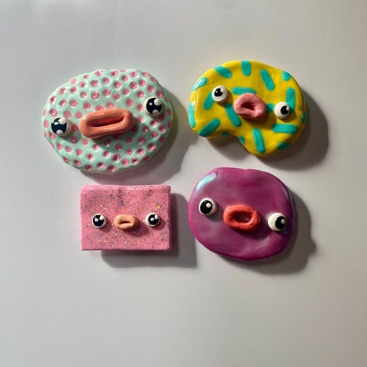 three donuts with different designs on them sitting next to each other in front of a white surface