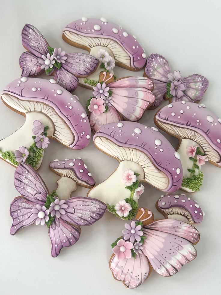 decorated cookies with purple and white butterflies on top of each cookie, all in the shape of mushrooms