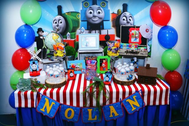 thomas the tank engine birthday party table with balloons and streamers on it's wall