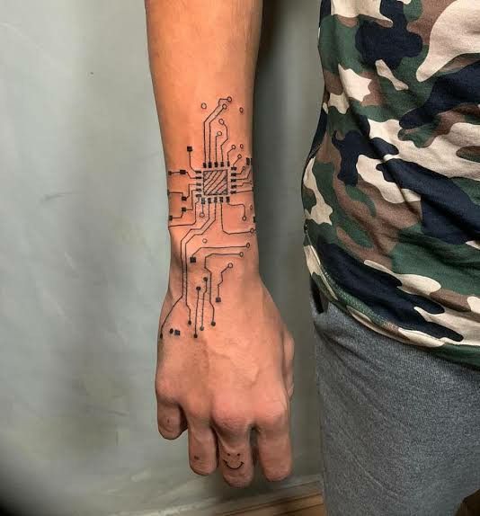 a person's arm with a circuit board tattoo on the left side of their hand