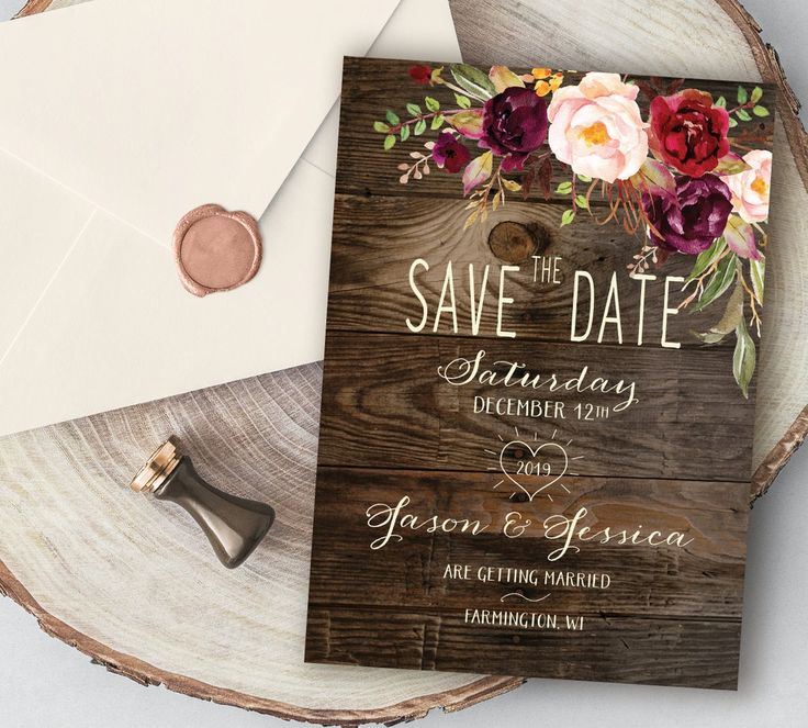 save the date card on top of a wooden table next to an envelope and wax stamp