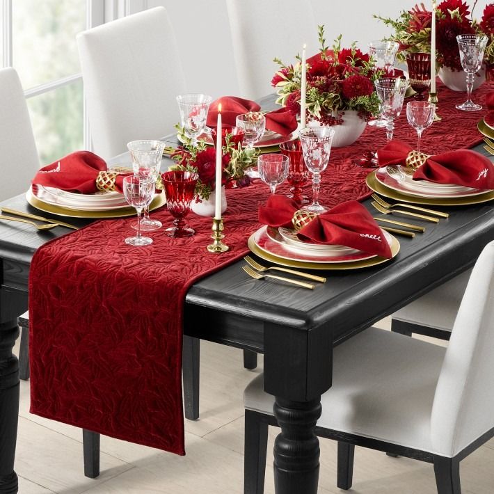 the table is set with red and gold place settings