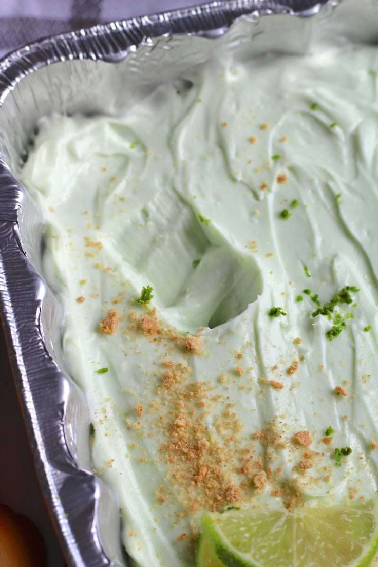 a pan filled with white frosting and lime slices