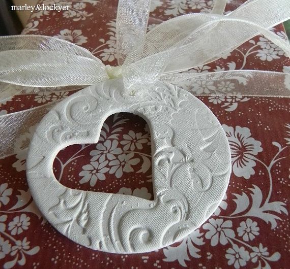 a white heart shaped ornament tied to a ribbon