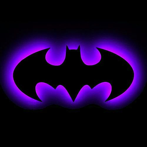 the batman symbol is glowing purple in the dark