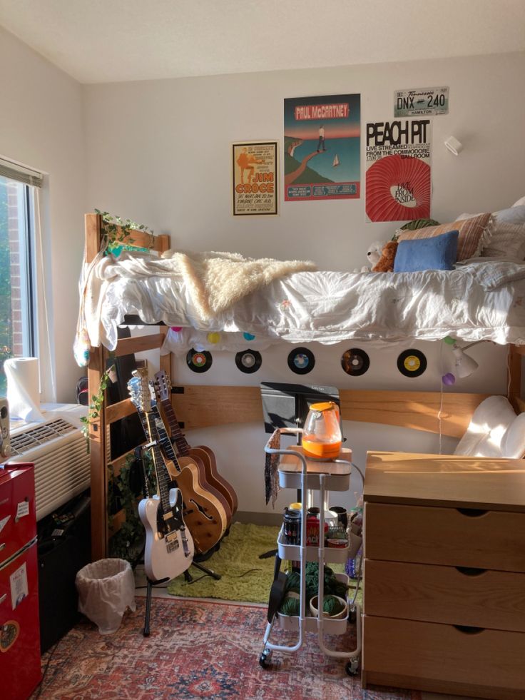 a bedroom with a bed, desk and guitar on the wall next to it's windows