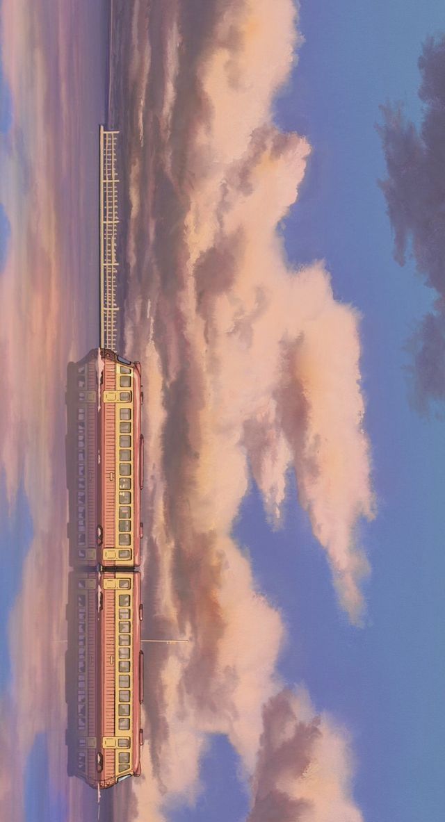 a train traveling down tracks next to clouds in the sky and on top of it