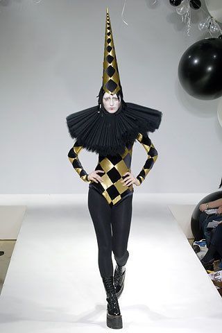 a woman is walking down the runway wearing a costume