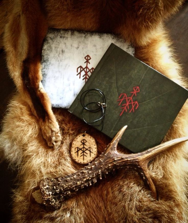 a book, keychain and deer antler are on the fur with other items