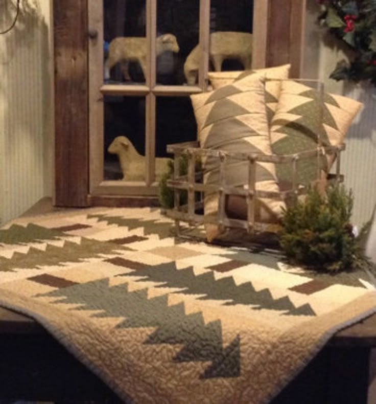 a bed covered in pillows and blankets next to a window with christmas wreaths on it