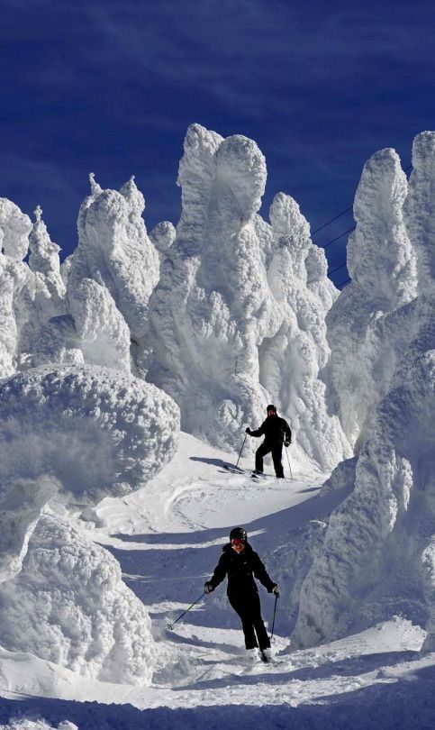 two people skiing down a snow covered slope