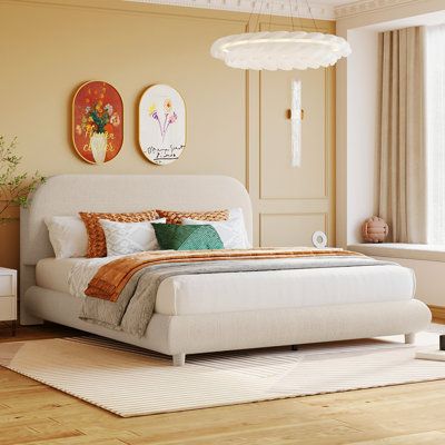 a white bed sitting in a bedroom on top of a hard wood floor next to a window