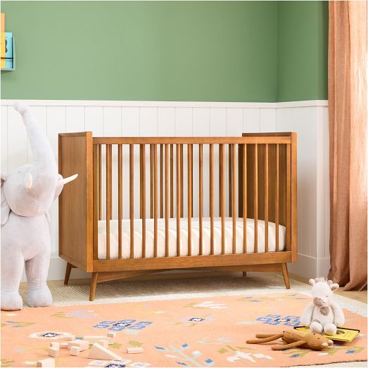 an elephant standing next to a baby crib