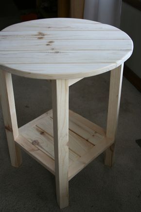 a round wooden table sitting on top of a carpeted floor