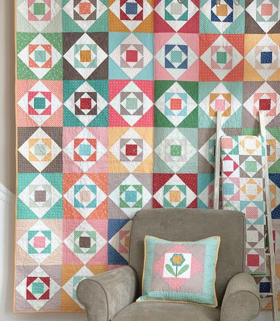 a chair sitting in front of a colorful quilt