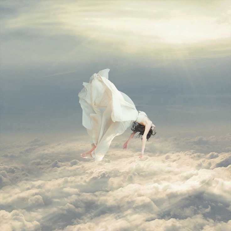 a woman flying through the air on top of clouds