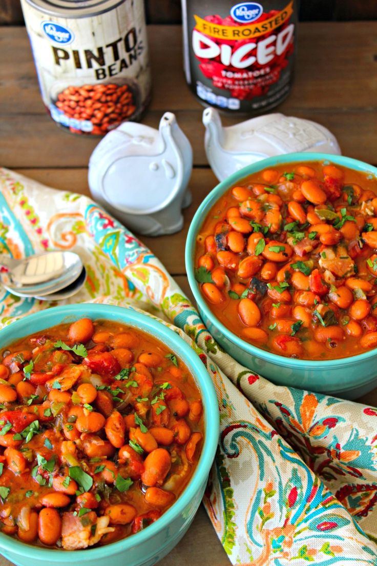 two bowls filled with beans on top of a table