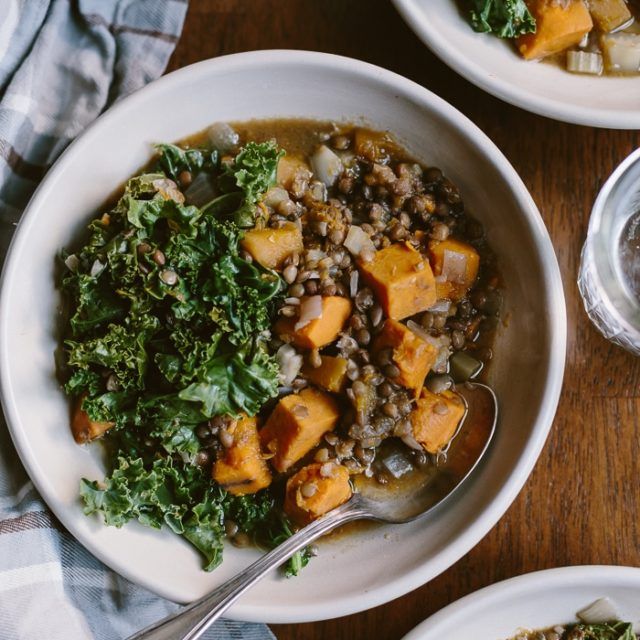 three bowls filled with food sitting on top of a wooden table next to silverware