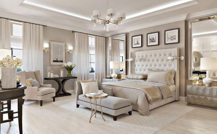 a large bedroom with white furniture and beige decor on the walls, carpeted flooring