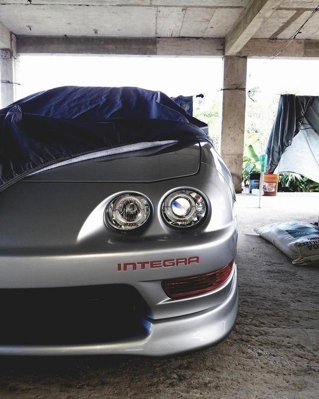 the front end of a silver sports car in a garage