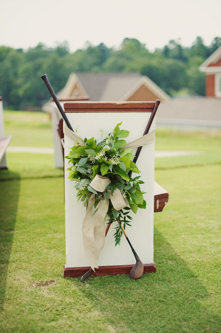 an outdoor ceremony set up with flowers and golf clubs