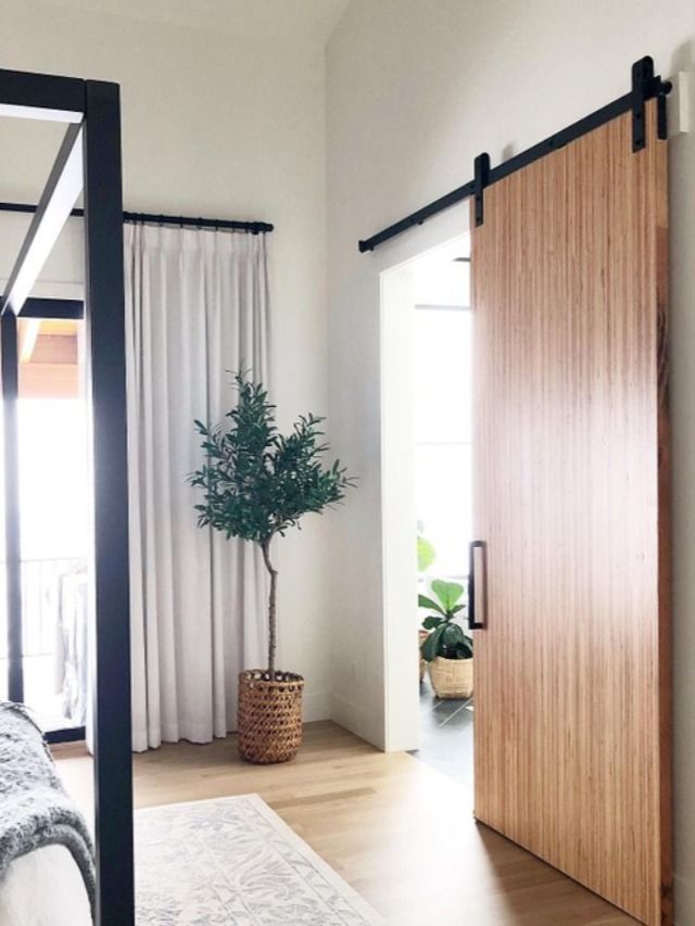 a bed sitting next to a wooden sliding door in a bedroom on top of a hard wood floor