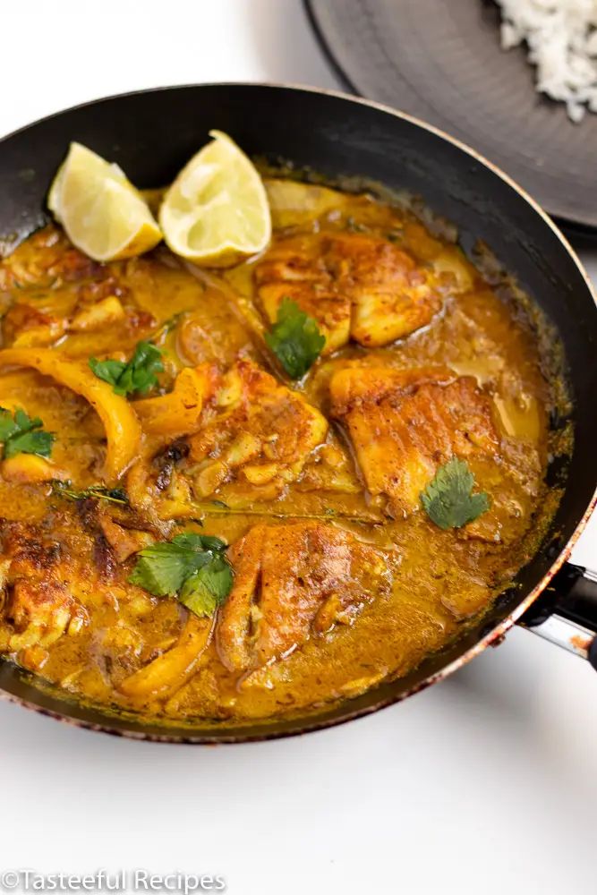 a skillet filled with chicken and vegetables on top of a white counter next to rice