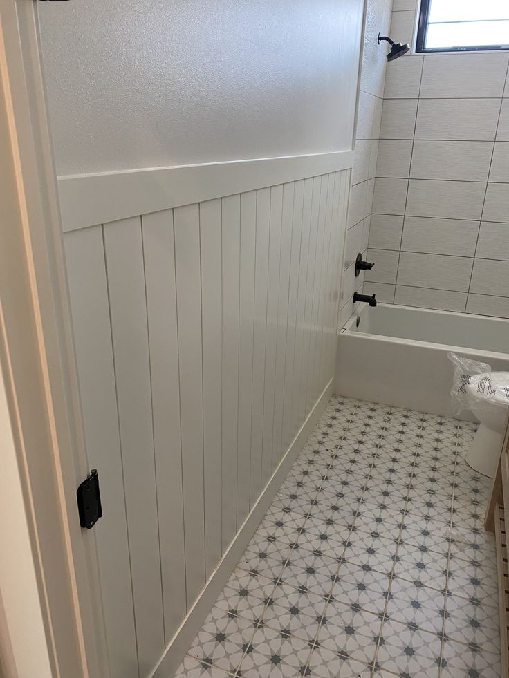 a bathroom with white and black tile flooring