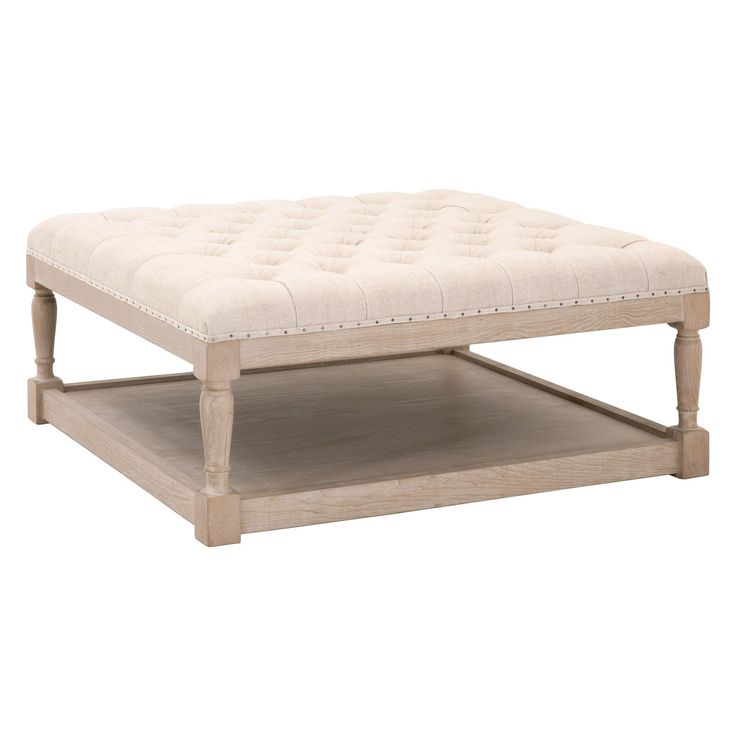 a white ottoman sitting on top of a wooden table