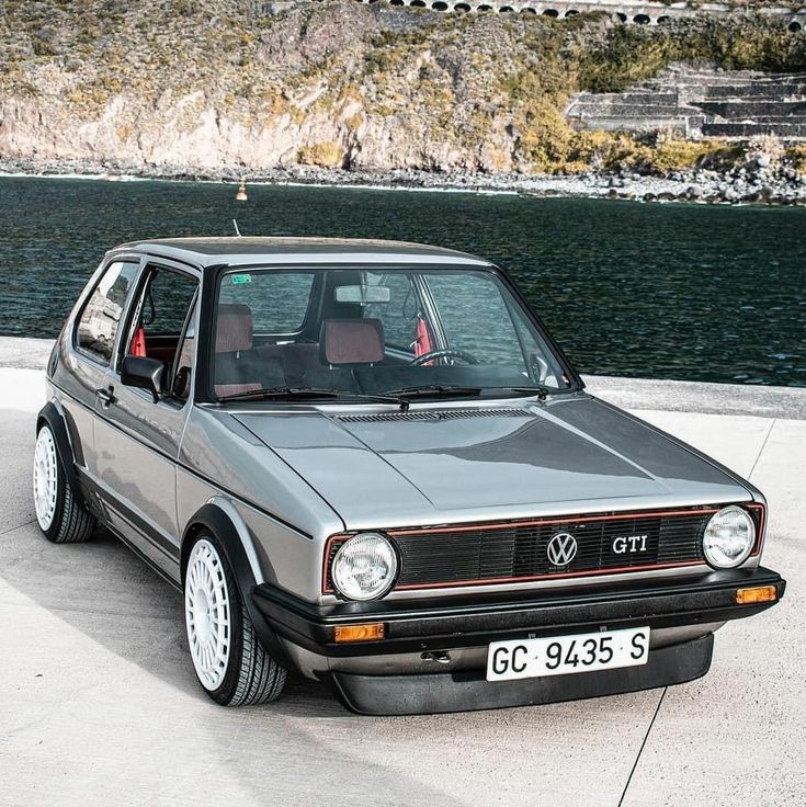 a grey car parked next to a body of water