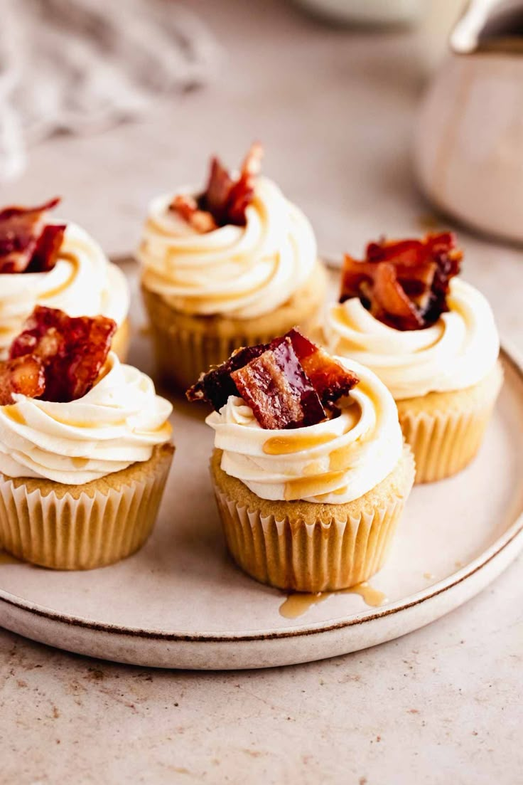 cupcakes with bacon on top sitting on a plate