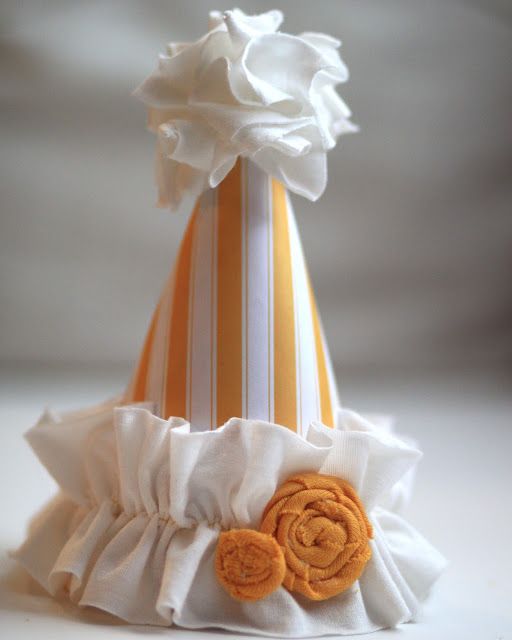 an orange and white striped hat with flowers on it